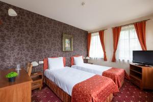 ein Hotelzimmer mit zwei Betten und einem Fernseher in der Unterkunft Hotel Hadjiite in Kopriwschtiza