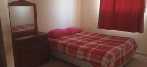 a bedroom with a bed and a dresser and a mirror at دار للكراء التضامن in Taroudant