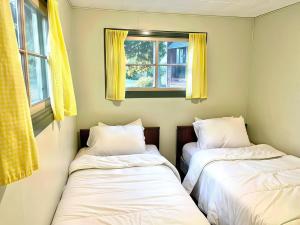 3-Bedroom Cottage #7 - Ambleside في كاوارثا ليك: سريرين في غرفة ذات نافذتين