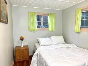 3-Bedroom Cottage #7 - Ambleside في كاوارثا ليك: غرفة نوم بها سرير ونافذتين