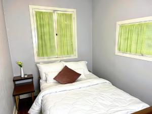 3-Bedroom Cottage #7 - Ambleside في كاوارثا ليك: سرير في غرفة نوم مع نافذتين