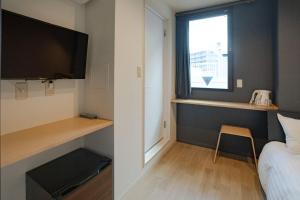 Una pequeña habitación con una cama y una ventana. en Tokyo Biyori Hotel - Vacation STAY 07393v, en Tokio