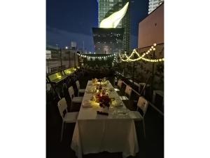 Una mesa larga en la azotea de un edificio por la noche. en Tokyo Biyori Hotel - Vacation STAY 07393v, en Tokio