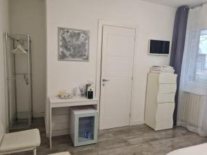a white room with a desk and a door at Villa Cristalli clinica pc in Piacenza