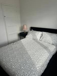 Lemingtonにある2 bedroom flat in Newcastle - Free street parkingのベッドルーム1室(白いベッド1台、ランプ、ドア付) +1枚の写真