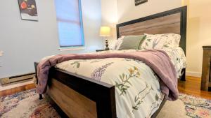 a bedroom with a large bed with a wooden headboard at Relaxing Rustic Oasis, Unit A - 6 minute walk to Downtown! Pet-friendly & Cyclists Welcome! in Cumberland
