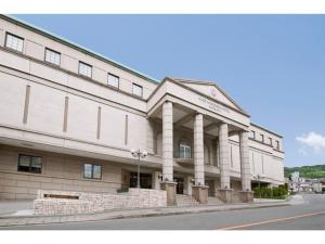 a large white building with columns on a street at K,M,H Art hotel by Kure Morisawa - Vacation STAY 23310v in Kure