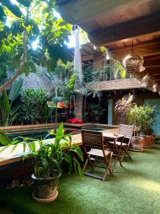 a patio with a table and chairs and plants at Casa Frutas y Verduras in Puerto Escondido