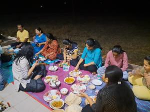a group of people sitting around a table eating food at Sea view villa in Kondivli +20 photos
