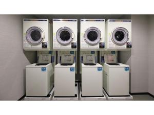 eine Reihe von Waschmaschinen und Trocknern in einem Laden in der Unterkunft Smile Hotel Kanazawa Nishiguchi Ekimae - Vacation STAY 11484v in Kanazawa + 17 Fotos