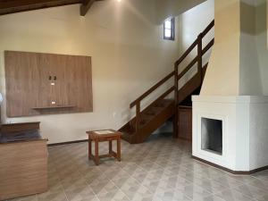 a living room with a fireplace and a staircase at Pousada Recanto Do Costão in Florianópolis