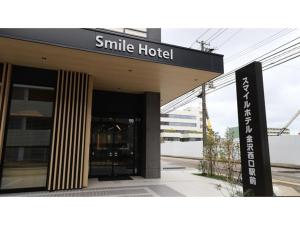 ein kleines Hotel mit einem Schild davor in der Unterkunft Smile Hotel Kanazawa Nishiguchi Ekimae - Vacation STAY 11491v in Kanazawa