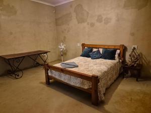 a bedroom with a bed with blue pillows and a table at Boemsies in Jacobsdal