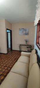 a living room with a white couch and a table at Casa Jardim da Colina in Igarassú +2 photos