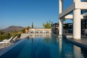 a swimming pool in front of a building with a resort at Villa Grand Fysaeri in Vamos +61 photos