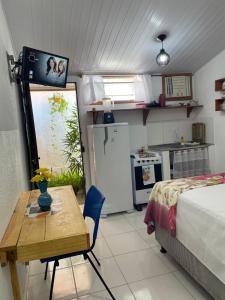 a room with a bed and a table and a kitchen at FLATS VASCONCELOS in Itacaré