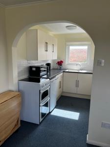 a kitchen with a stove and a sink and an archway at 186 Sundowner Holiday Park in Hemsby