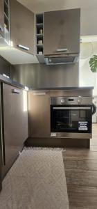 a kitchen with a microwave and a stove at Le calme ensoleillé in Paris +9 photos