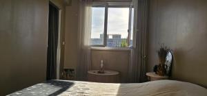 a bedroom with a bed and a window with a view at Le calme ensoleillé in Paris