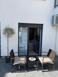a glass table and chairs next to a building at Studio7 center apartment Prizren in Prizren