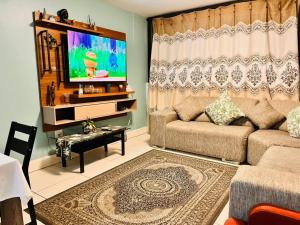 een woonkamer met een bank en een flatscreen-tv bij MORRO do MOCO in Windhoek