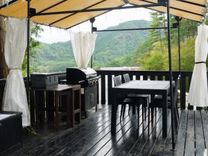 a deck with a stove and a table and chairs at TOCORO. Mt.Fuji CAMP & GLAMPING - Vacation STAY 23389v in Oishi +11 photos