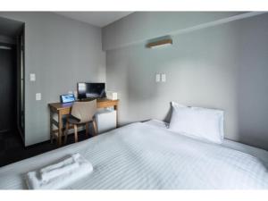 a bedroom with a bed and a desk with a computer at HOTEL STARRIZE - Vacation STAY 25108v in Fukuoka