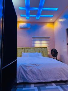 Schlafzimmer mit einem Bett mit blauem Licht in der Unterkunft LUXE 90 INTERNATIONAL HOTEL AND Suites in Wasimi-Aiyetoro