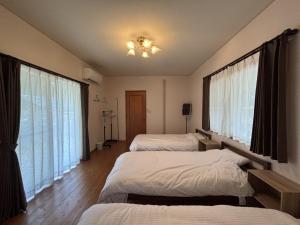 a bedroom with three beds and a window at ChillOut MINAMIASO - Vacation STAY 25172v in Minami Aso