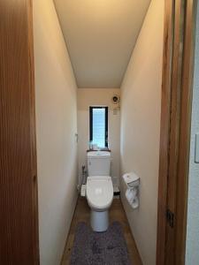 a small bathroom with a toilet and a window at ChillOut MINAMIASO - Vacation STAY 25172v in Minami Aso +10 photos