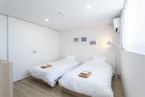 two beds in a white room with towels on them at CAN LI ASSO - Vacation STAY 25225v in Minami Aso +7 photos
