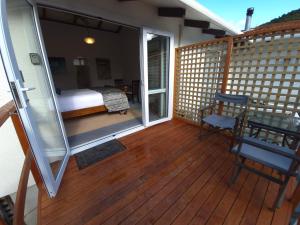 a room with a balcony with a bed and a table at Waikawa Retreat in Waikawa