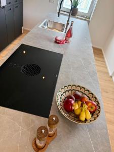 a bowl of fruit on a counter with a bowl of fruit at Lupi Grey - stylish und luxury Apartment in Buchen +16 photos