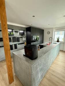 a kitchen with a large island in the middle at Lupi Grey - stylish und luxury Apartment in Buchen