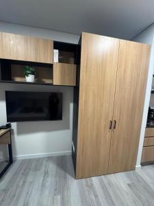 a large wooden cabinet in a room with a tv at Modern apartment with a beautiful panoramic view in Bogotá +3 photos