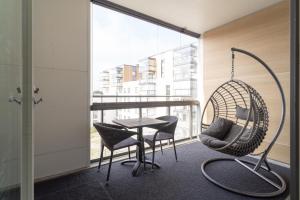 a room with a swing and a table and chairs at Modern 2BR apartment W 2 balconies, Metro, Helsinki 15min in Espoo