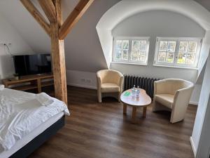 a bedroom with a bed and a table and chairs at Schloss Krugsdorf Golf & Hotel in Krugsdorf