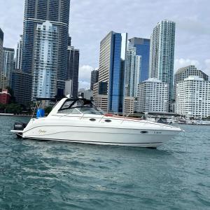 una barca bianca in acqua di fronte a una città di Party On The Seas a Miami