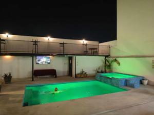 a person swimming in a swimming pool at night at Quinta Milenium in Monterrey