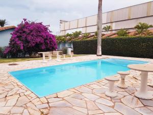a swimming pool with a table and a picnic table at Cravinhos Park Hotel in Cravinhos