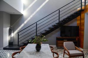 ein Wohnzimmer mit Tisch und Treppe in der Unterkunft Mezquite by Viadora in San Miguel de Allende