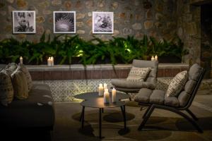 ein Wohnzimmer mit zwei Stühlen und einem Tisch und Kerzen in der Unterkunft Mezquite by Viadora in San Miguel de Allende