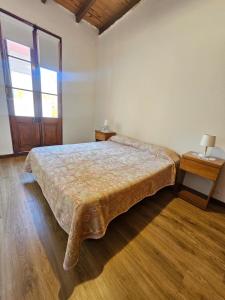 a bedroom with a bed and a wooden floor at Casa Moré centrica con cochera doble in Rosario