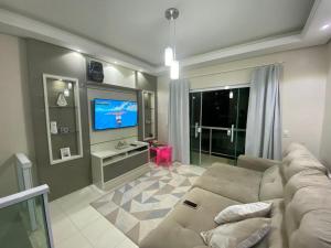 un soggiorno con divano e TV a schermo piatto di Casa aconchegante, próxima a praia a Governador Celso Ramos