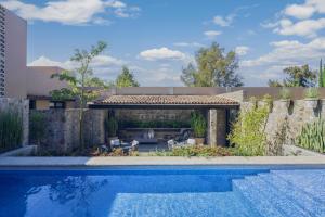 ein Swimmingpool in einem Hof mit einem Haus in der Unterkunft Mezquite by Viadora in San Miguel de Allende