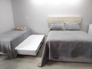 two beds sitting next to each other in a room at StudioD in Passo Fundo +2 photos