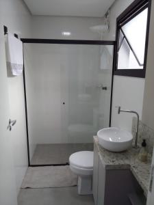 a white bathroom with a toilet and a sink at StudioD in Passo Fundo