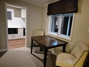 a dining room with a table and chairs and a window at Bradleys Garden Bed and Breakfast in Taumarunui
