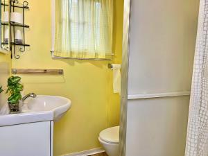 Un baño con un lavabo blanco y un inodoro. en Ambleside - 2-Bedroom Cottage #10, en Kawartha Lakes