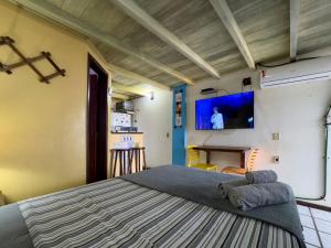 a bedroom with a large bed and a flat screen tv at Vista Mar em Búzios Praia de Geribá c/ Piscina in Búzios